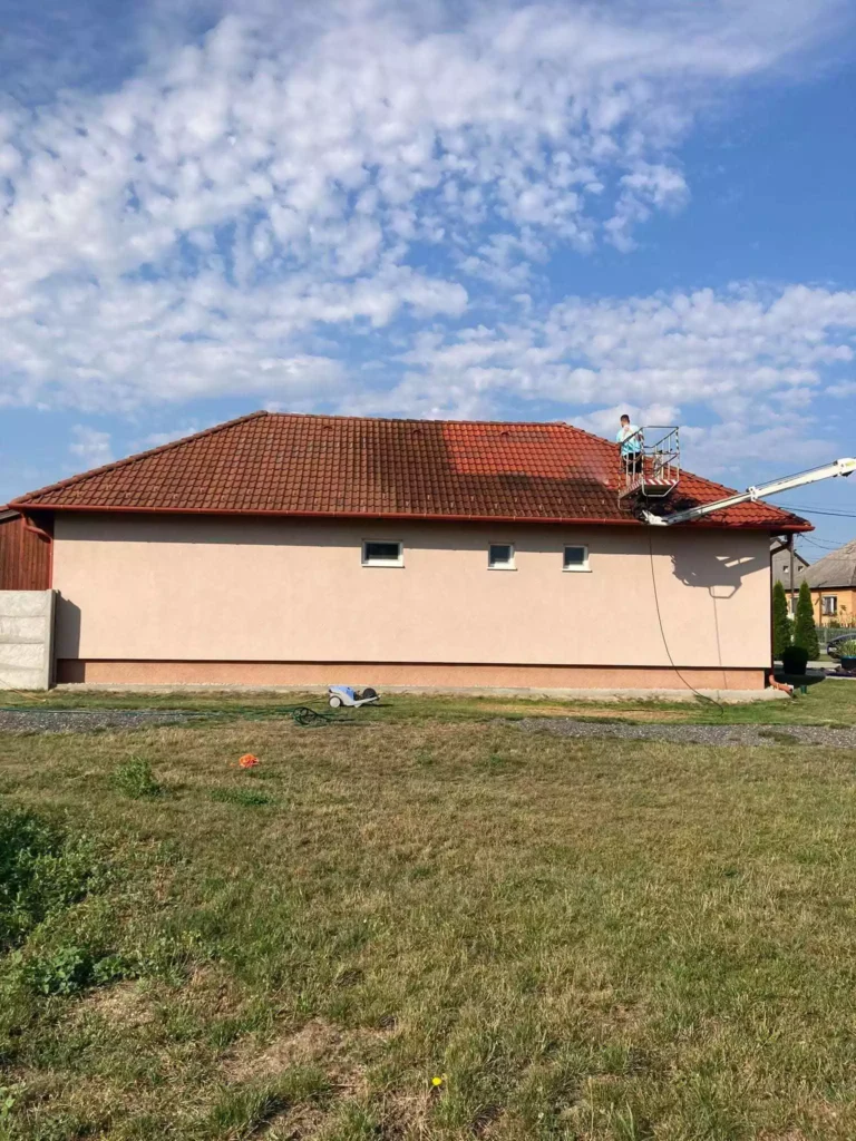 Profesionálne čistenie strechy bungalovu v Nitre – pracovník na hydraulickej plošine s viditeľným rozhraním čistej a znečistenej časti